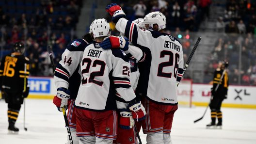 New York Rangers players Nick Ebert and Tim Gettinger celebrate with teammates on ice